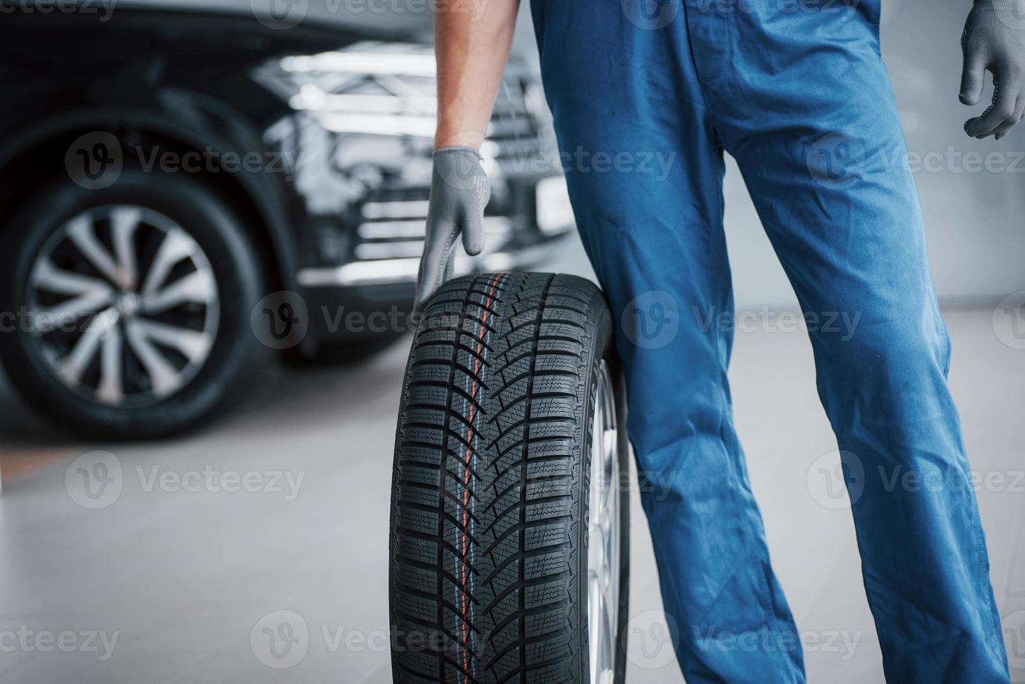 een monteur met een bandenbus in een reparatiegarage. vervanging van winter- en zomerbanden foto