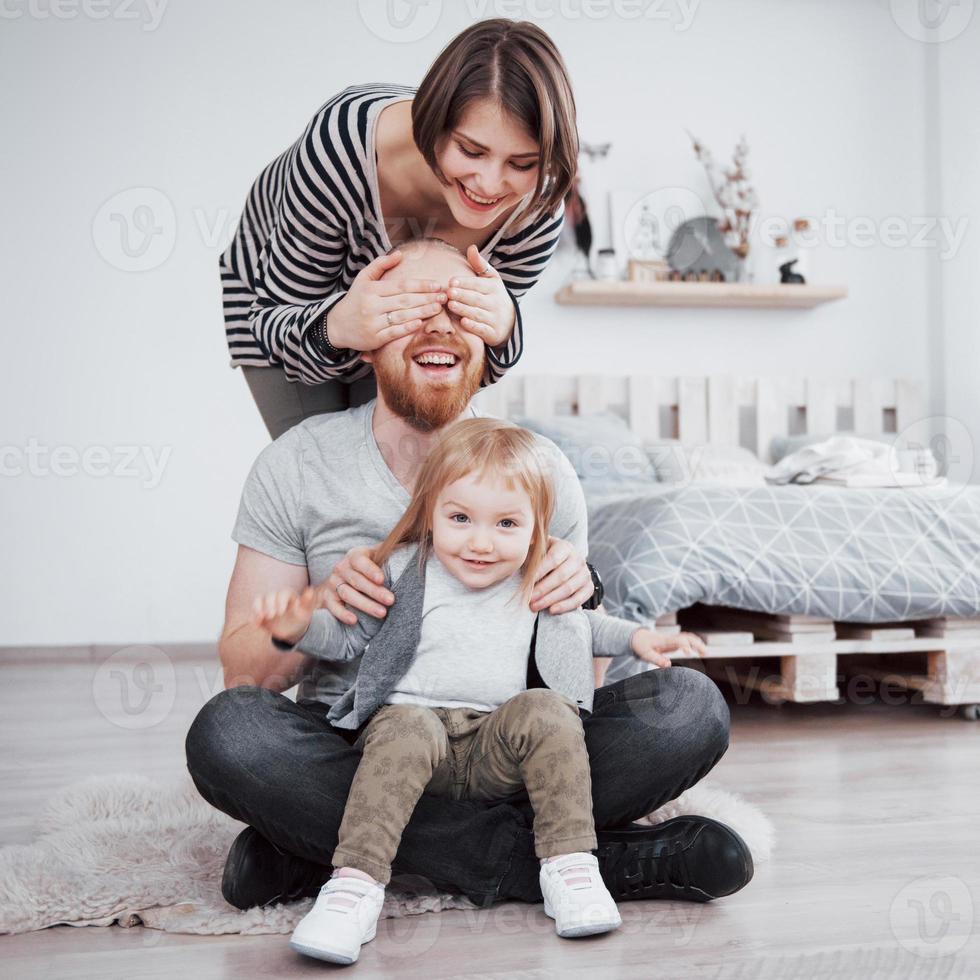 gelukkige familie moeder, vader en kind dochter thuis foto