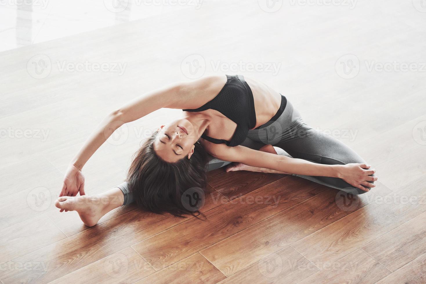 een gymnaste vrouw uitrekken maakt een splitsing, een touw in een sportschool. foto