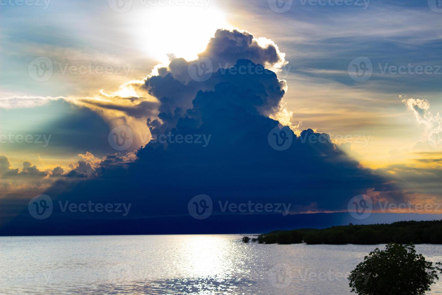 zonsondergang Bij zee met een wolk in de achtergrond foto