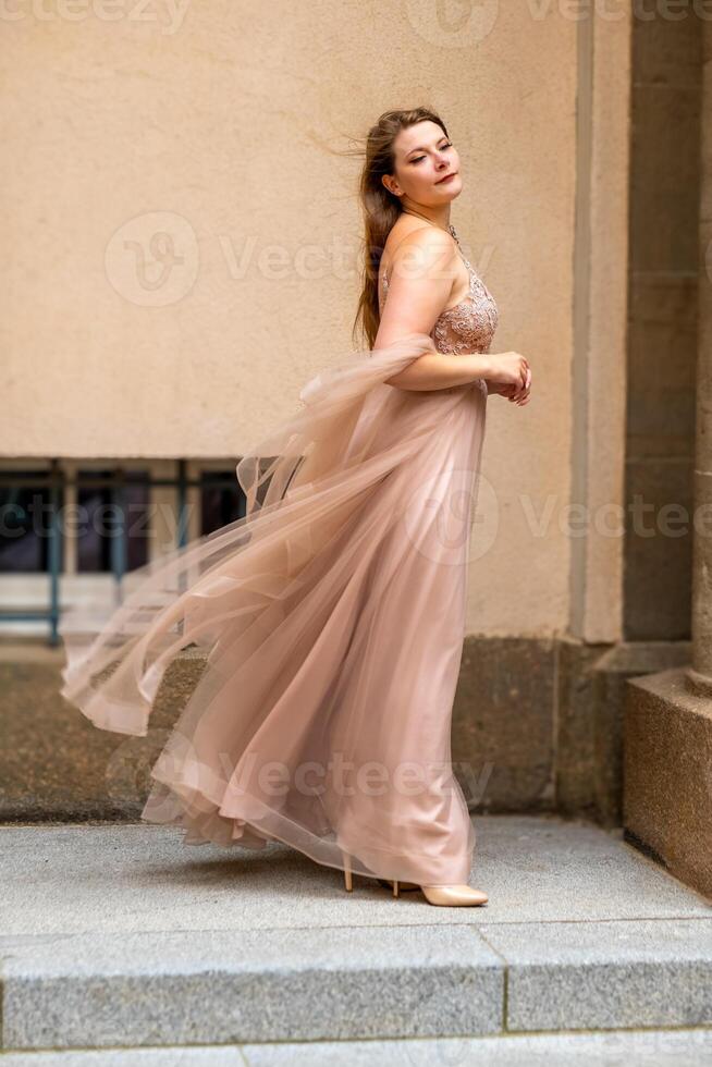 een vrouw in een room gekleurde jurk net zo een prinses in de wind foto