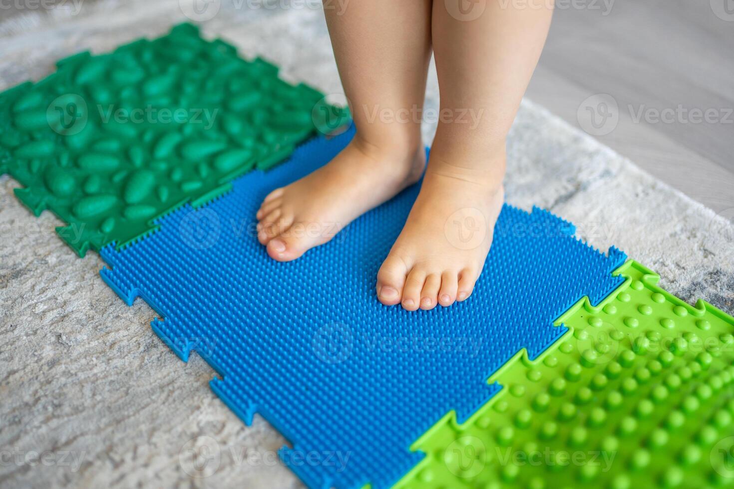 dichtbij omhoog visie van weinig meisje wandelingen Aan een massage mat. kleuter baby voet massage mat. opdrachten voor poten orthopedische massage tapijt. foto