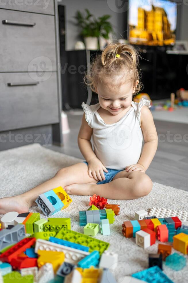 Kaukasisch kind een weinig meisje is spelen in de bouwer Bij huis. leerzaam speelgoed voor kinderen. foto