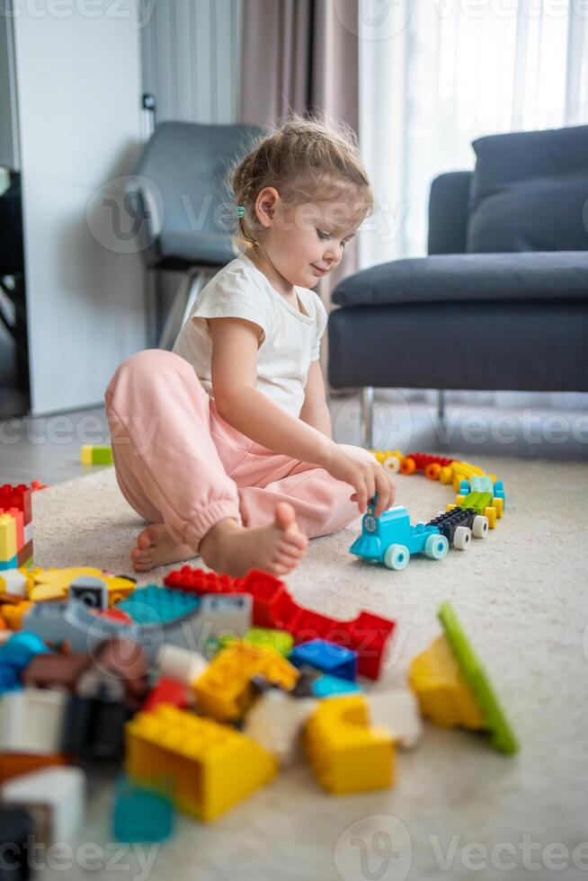 weinig meisje Speel met bouwer speelgoed- Aan verdieping in huis, leerzaam spel, uitgeven vrije tijd activiteiten tijd concept foto