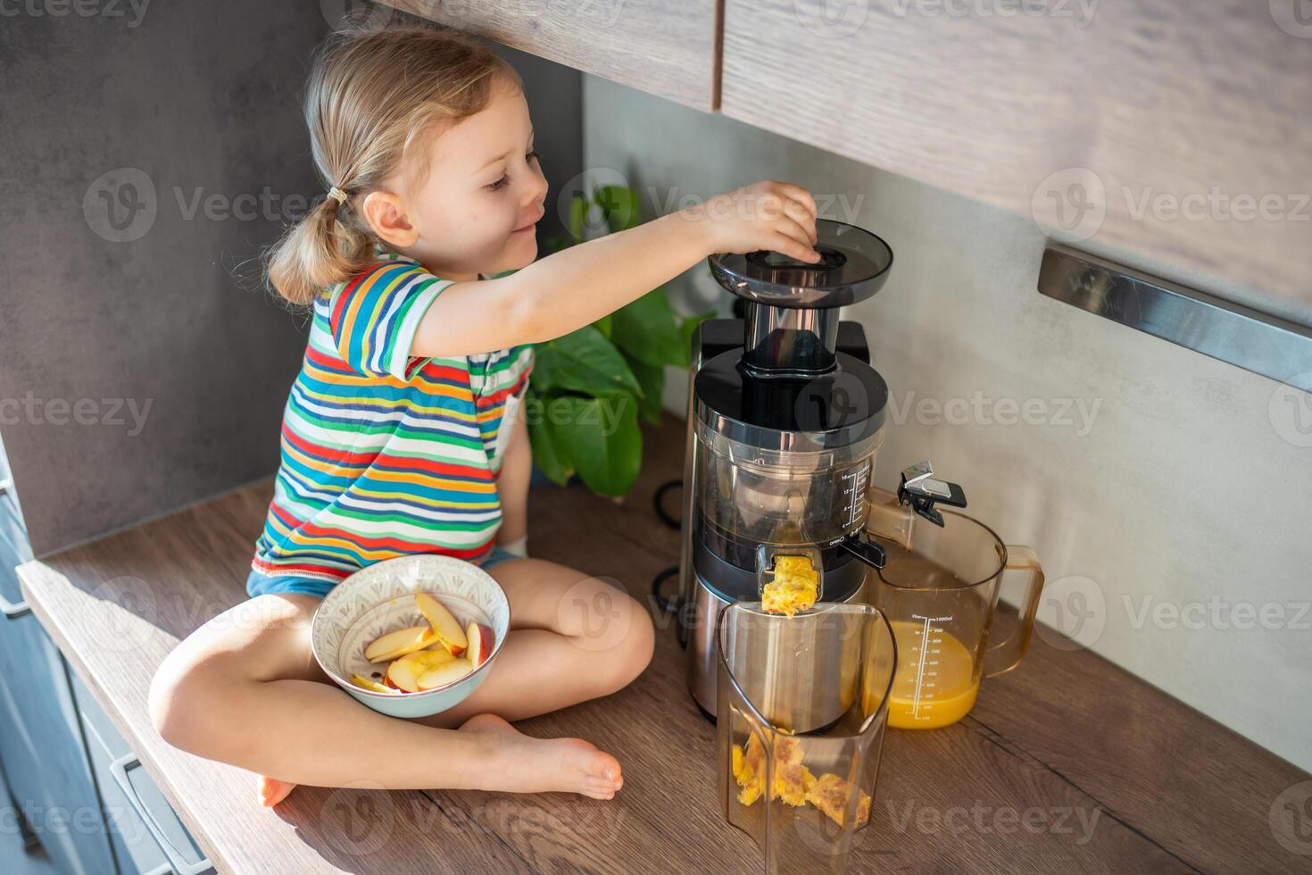 weinig meisje maken vers sap zittend Aan de tafel in huis keuken foto