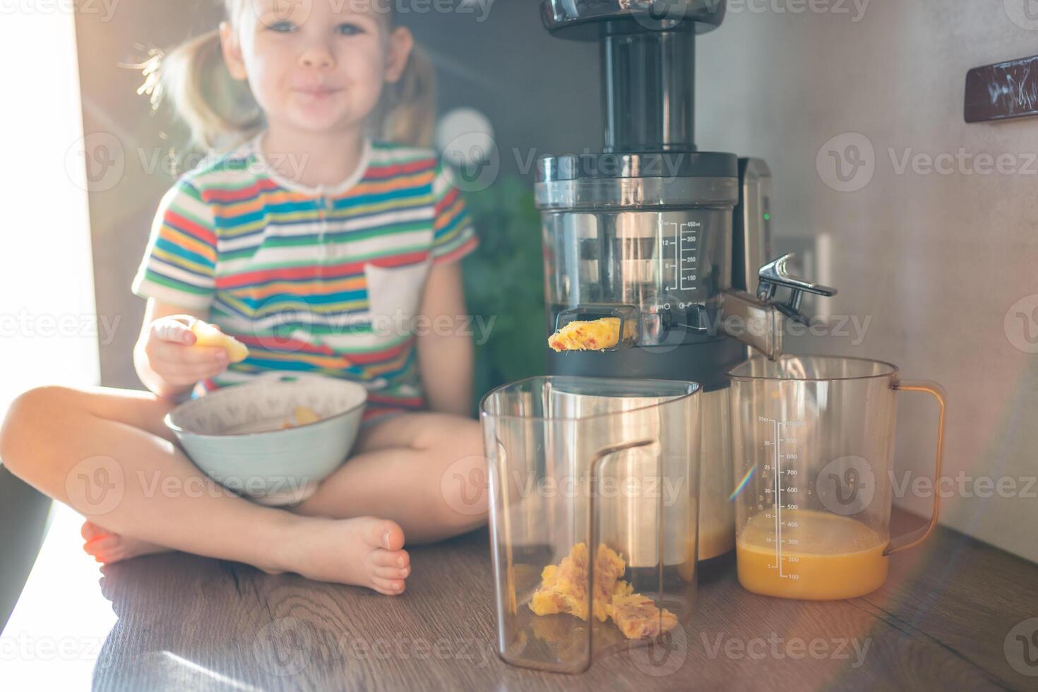 weinig meisje maken vers sap Aan de tafel in huis keuken. focus Aan sapcentrifuge foto