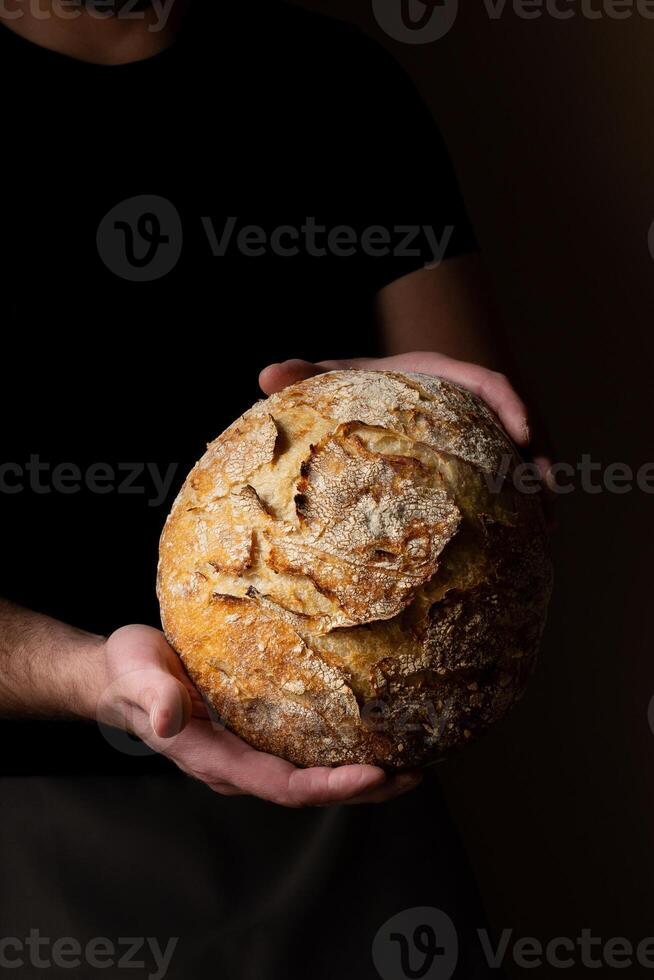 aantrekkelijk jong Kaukasisch chef poseren met wit zuurdesem brood. foto