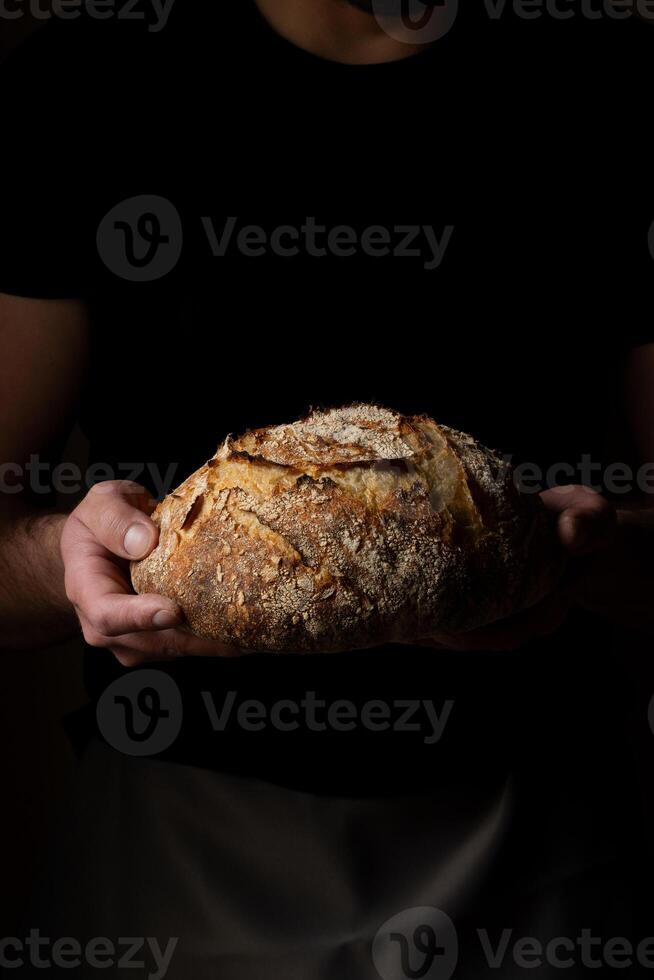 aantrekkelijk jong Kaukasisch chef poseren met wit zuurdesem brood. foto