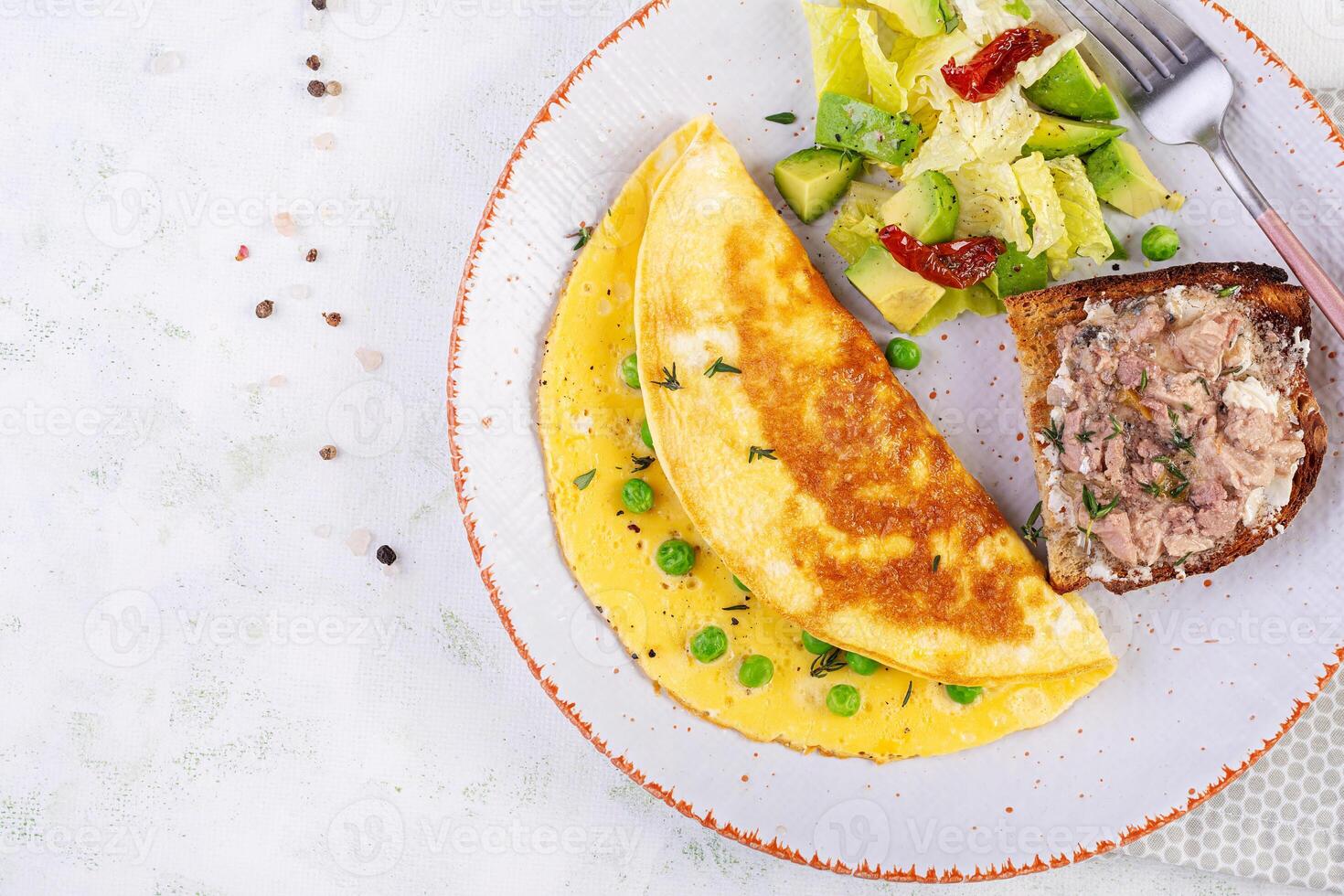 omelet met groen erwten en geroosterd brood met kabeljauw lever Aan wit bord. frittata - Italiaans omelet. top visie, vlak leggen foto