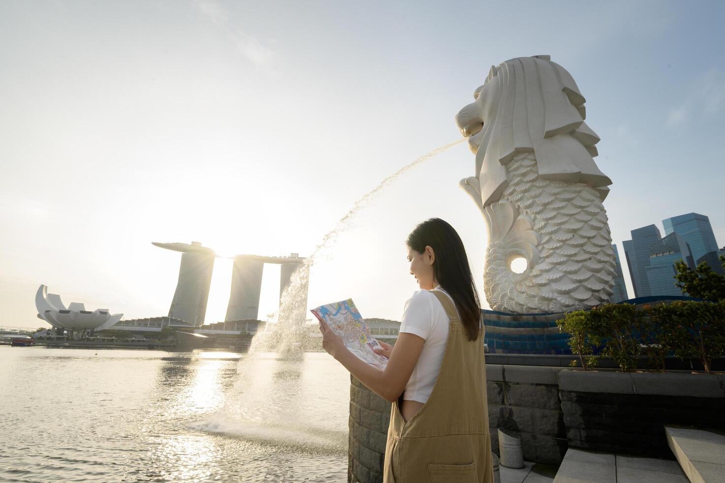 een vrouw in merlion fontein in voorkant van de jachthaven baai foto