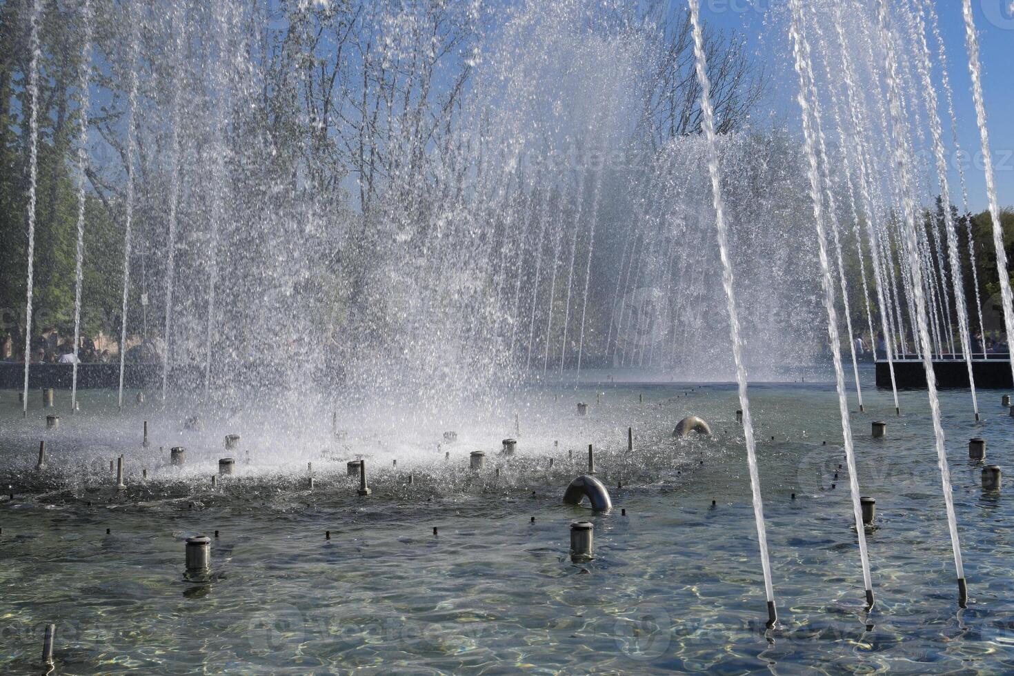 stad fontein in de stad van krasnodar. mensen zijn wandelen door de fontein. water spatten. foto