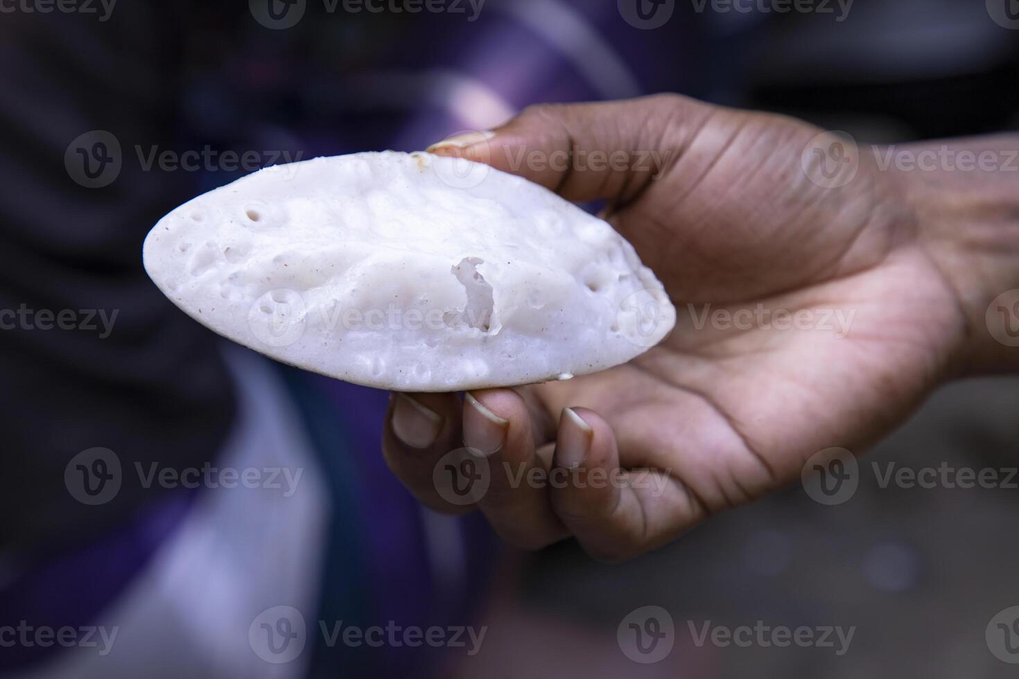 hand vasthouden traditioneel handgemaakt chitoi pitha met een Ondiep diepte van veld- foto
