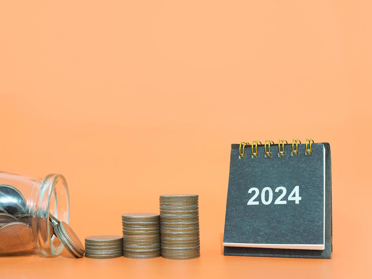 2024 bureau kalender en stack van munten. de concept van bedrijf groei, financieel investering, markt voorraad, winst opbrengst, dividend en bedrijf fonds in jaar 2024 foto