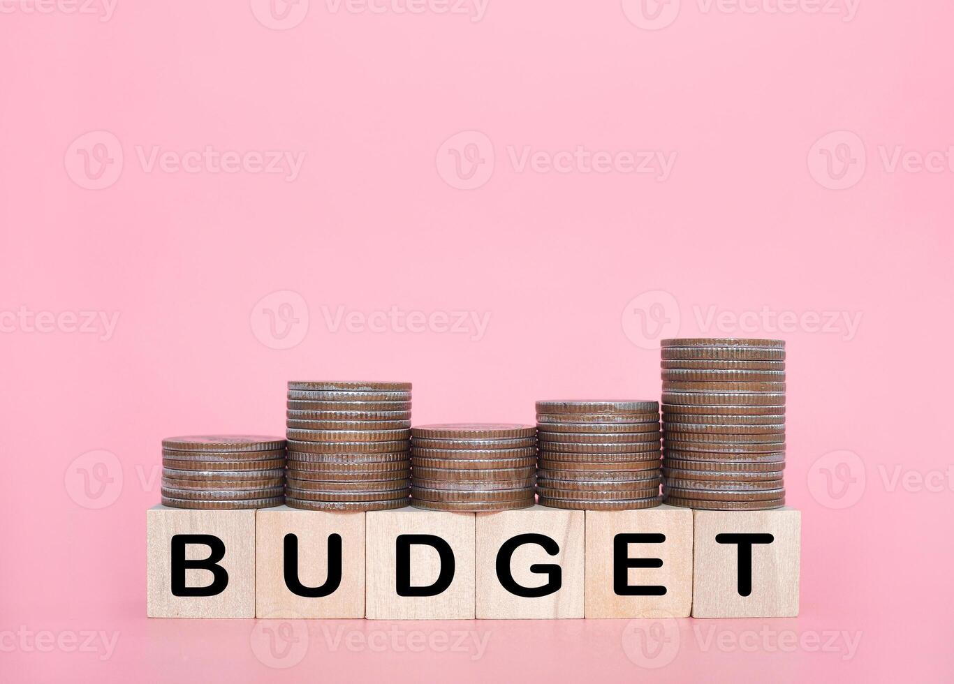 houten blokken met de woord begroting en stack van munten. de concept over begroting planning en toewijzing foto