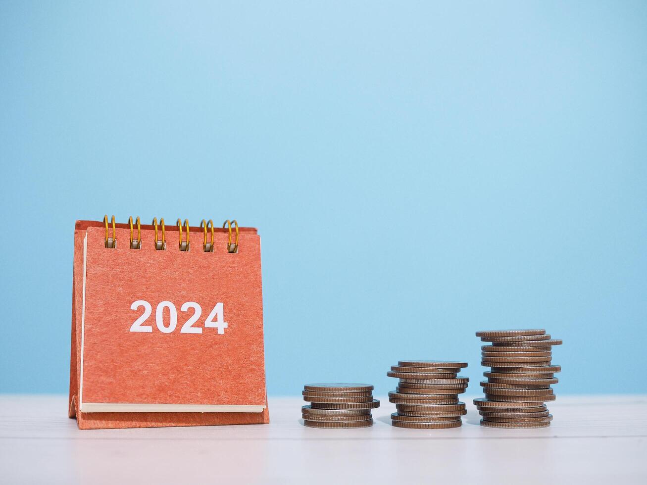 2024 bureau kalender en stack van munten. de concept van bedrijf groei, financieel investering, markt voorraad, winst opbrengst, dividend en bedrijf fonds in jaar 2024 foto