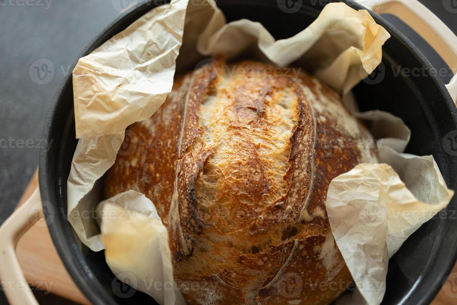 vers zelfgebakken zuurdesem brood in gips ijzer pan Aan houten snijdend bord, detailopname foto