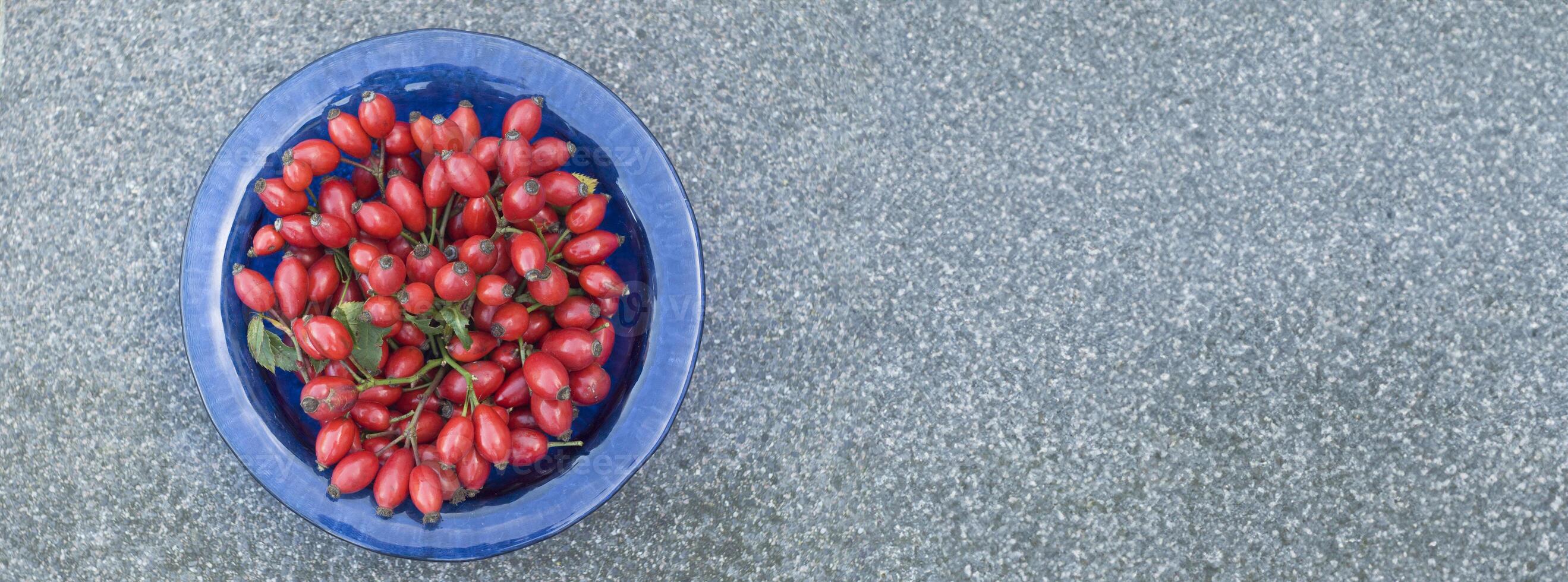 blauw kom gevulde met oogst van rijp rood roos heupen, alternatief geneesmiddel, multivitamine thee ingrediënt voor hoesten foto