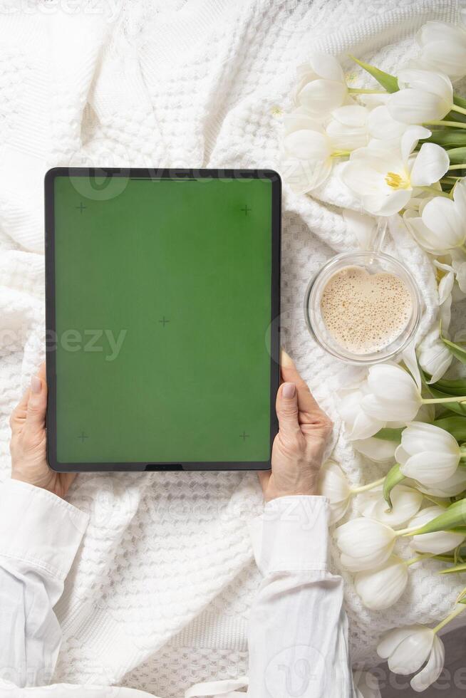 groen scherm tablet, jong vrouw op zoek voor moeder dag geschenk online, tulpen foto