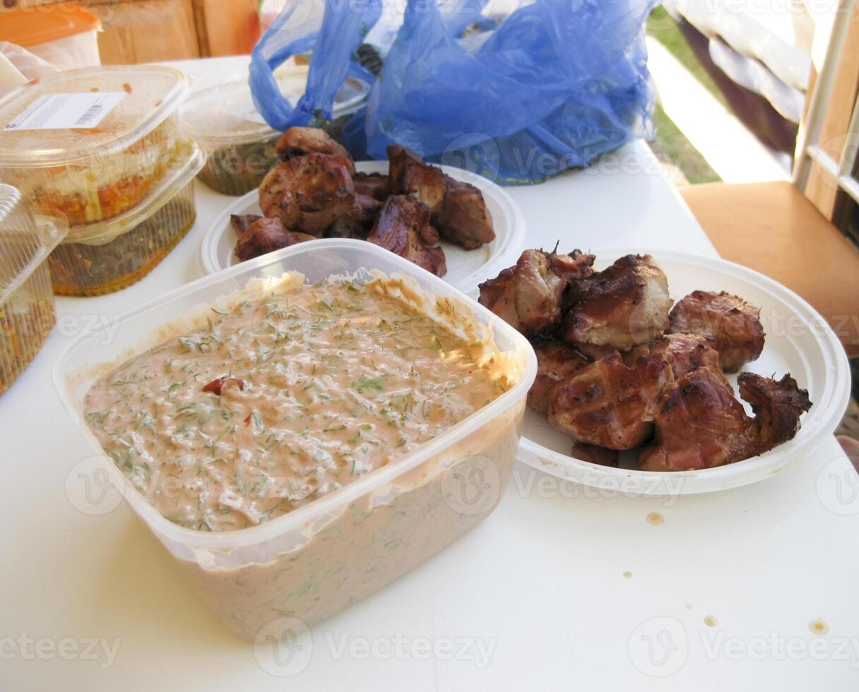 shish kebab in beschikbaar borden. gebakken vlees in plastic platen. foto