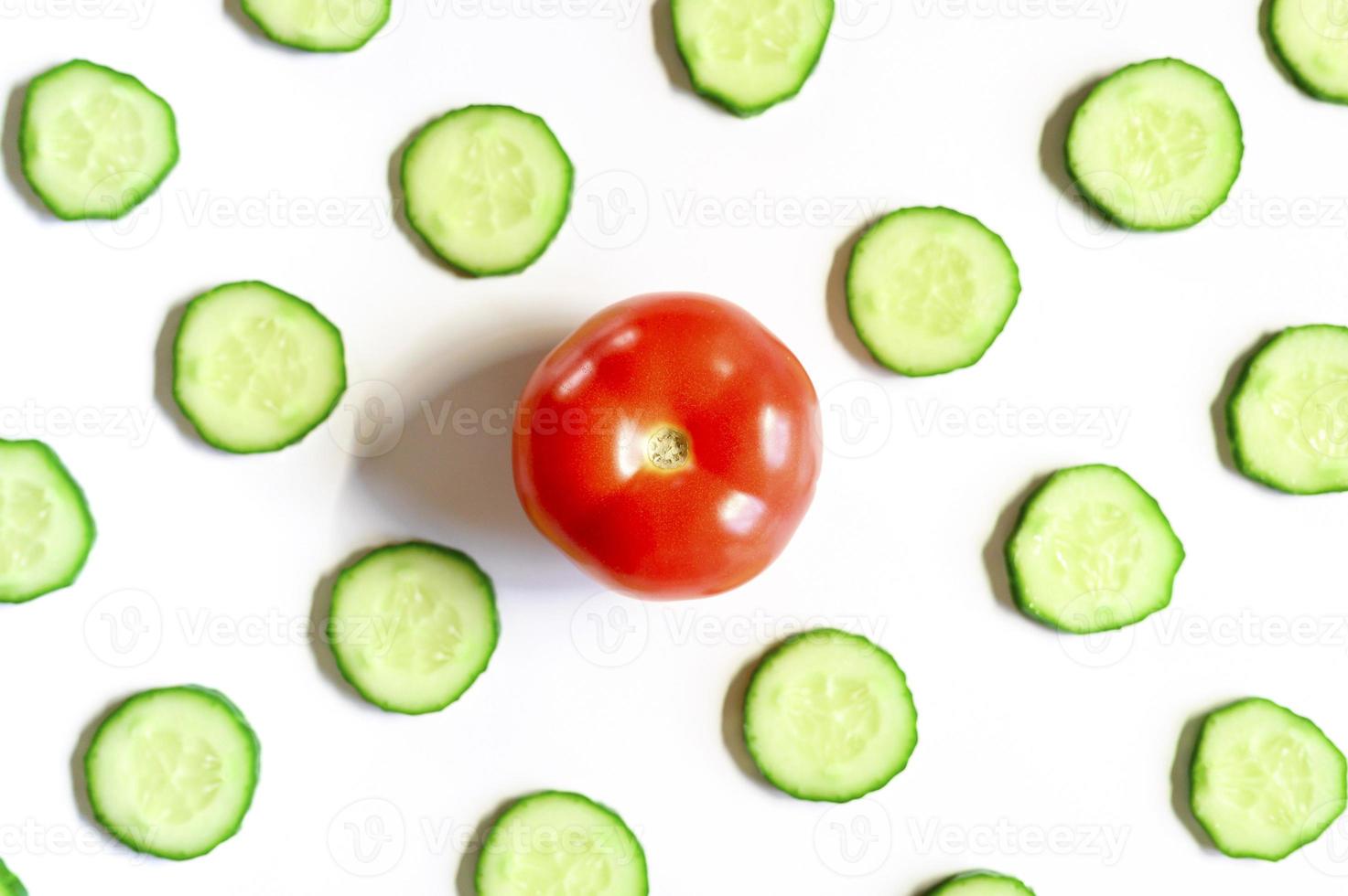 herhalend patroon van gesneden halve cirkels van verse rauwe groentekomkommers voor salade en tomaat foto