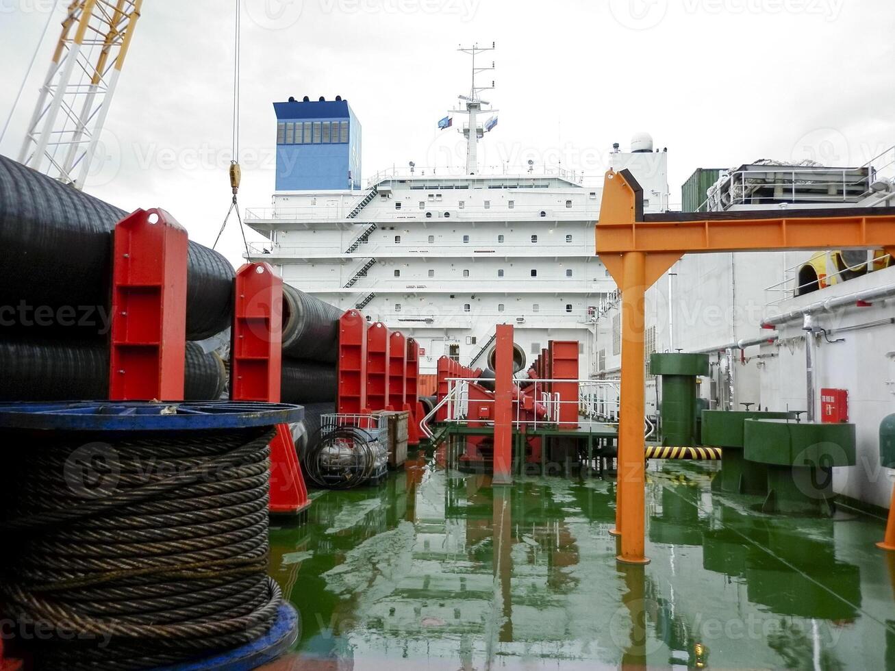 de dek leggen schuit. pijpen en hijs- kranen Aan de schip. uitrusting voor houdende een pijpleiding Aan de zeebedding foto