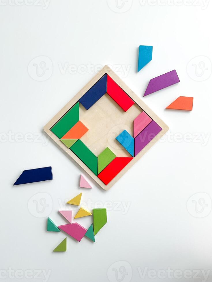 tangram spel. veelkleurig onderdelen zijn gedemonteerd Aan wit tafel. top visie Aan wit achtergrond foto