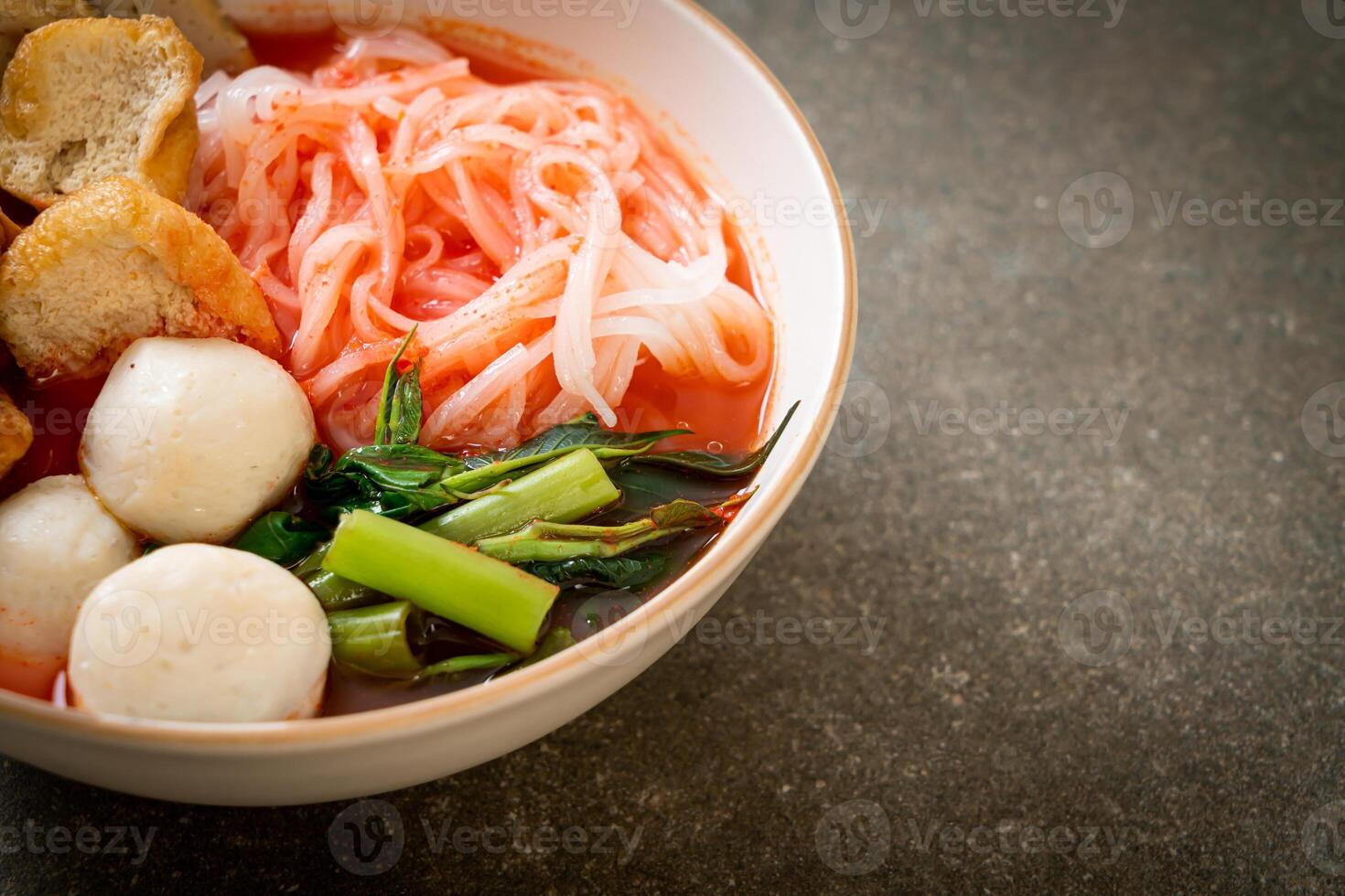 kleine platte rijstnoedels met visballetjes en garnalenballetjes in roze soep, yen ta four of yen ta fo foto