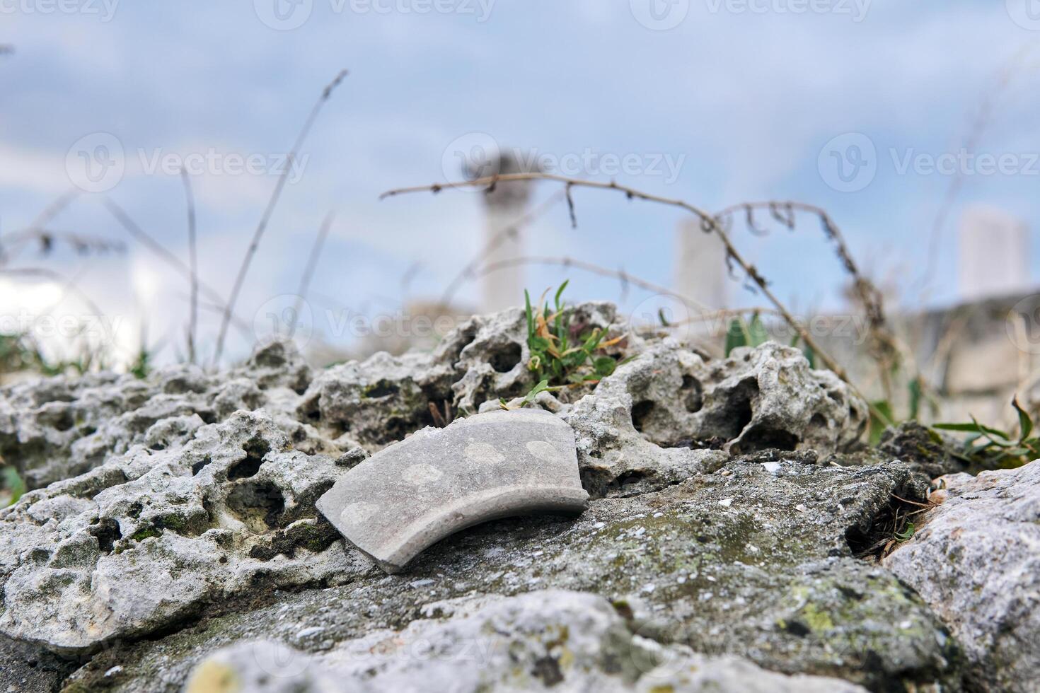 scherf van oude keramiek Aan een steen tegen een achtergrond van wazig oude ruïnes foto