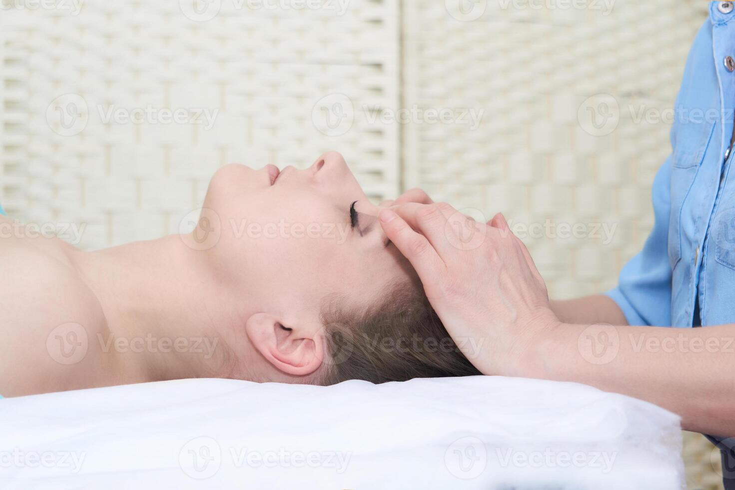 mooi jong vrouw krijgen gelaats massage in de spa salon foto