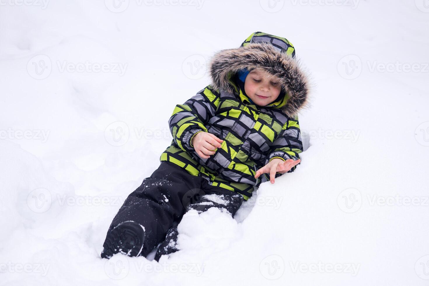 weinig kind spelen in de sneeuw in winter foto