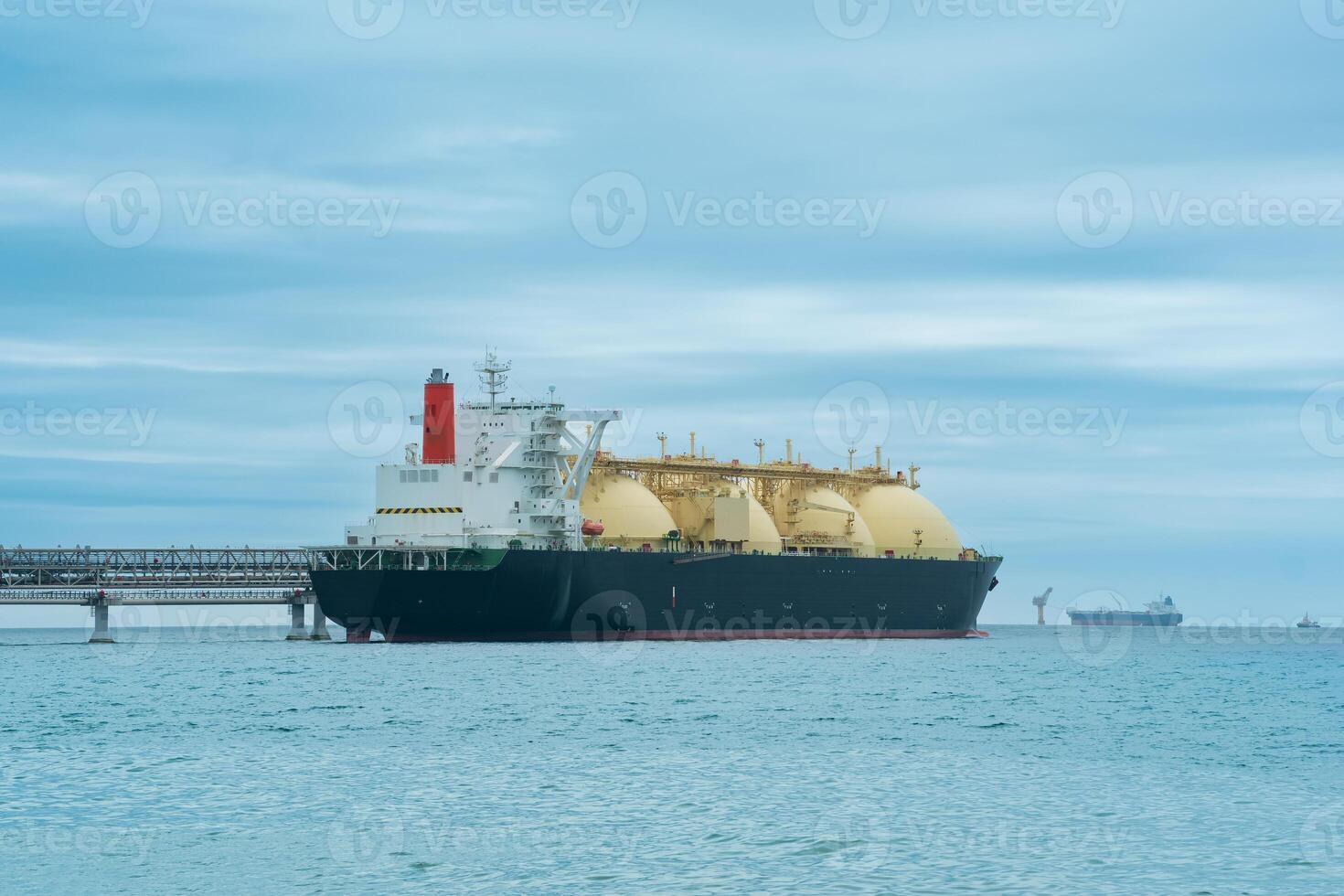 vloeibaar gemaakt natuurlijk gas- vervoerder tanker gedurende bezig met laden Bij een lng offshore terminal, in de afstand de olie exporteren terminal is zichtbaar in de zee foto