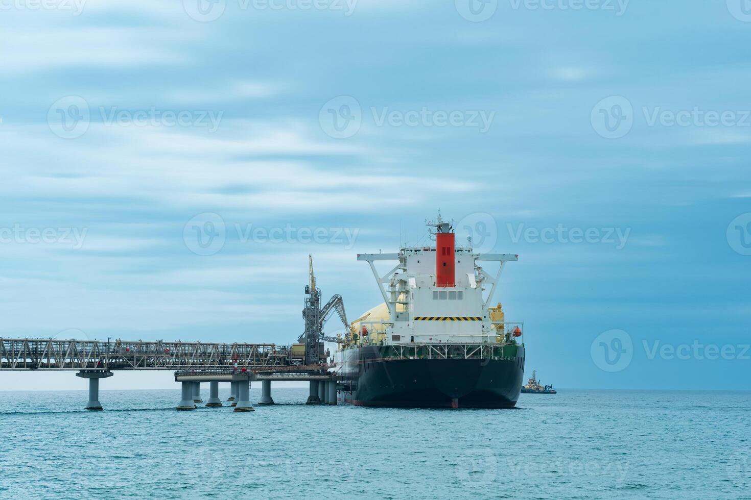 vloeibaar gemaakt natuurlijk gas- vervoerder tanker gedurende bezig met laden Bij een lng offshore terminal, in de afstand de olie exporteren terminal is zichtbaar in de zee foto