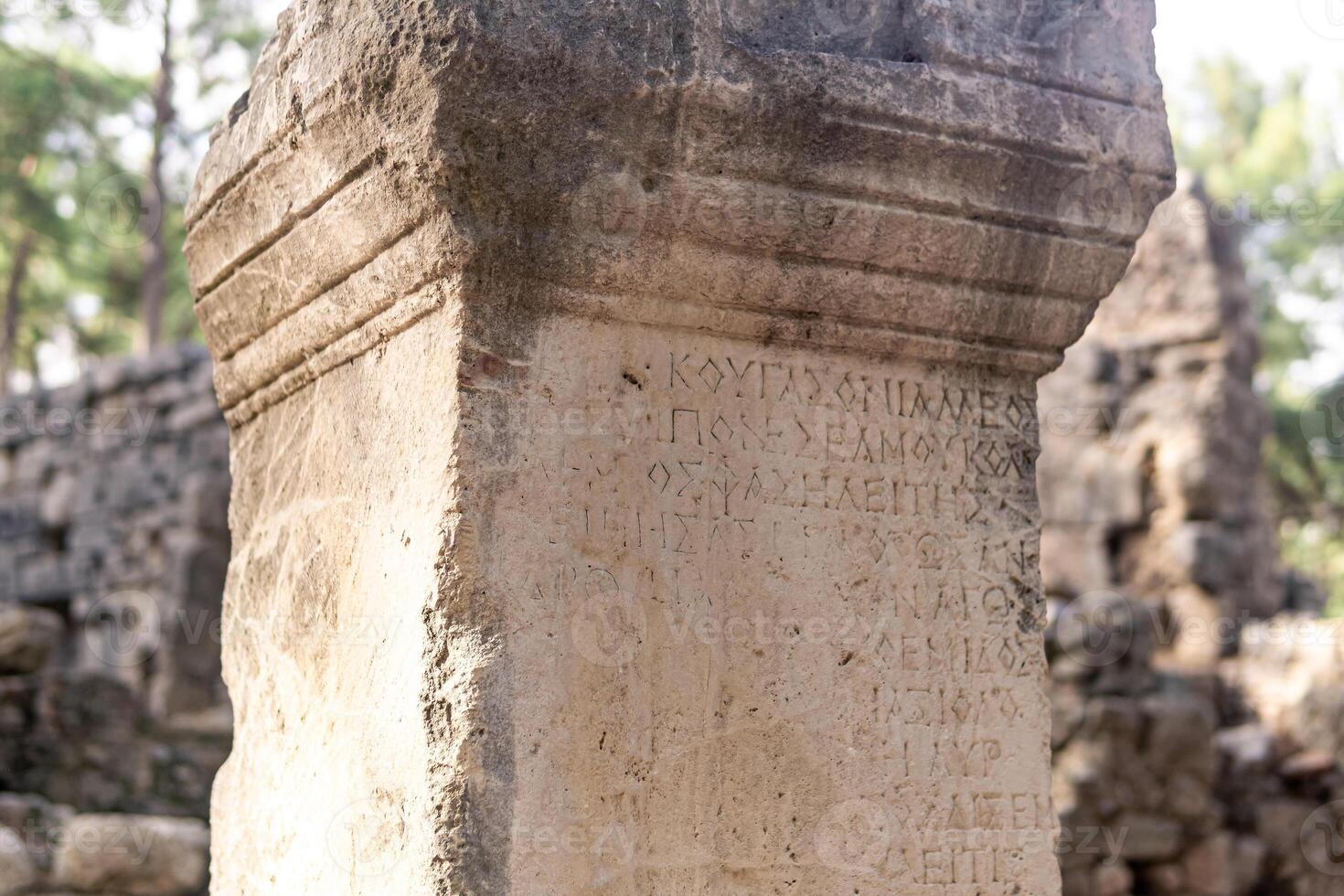 half gewist antiek opschrift Aan een steen tussen de ruïnes van de oude stad van faselis, kalkoen foto