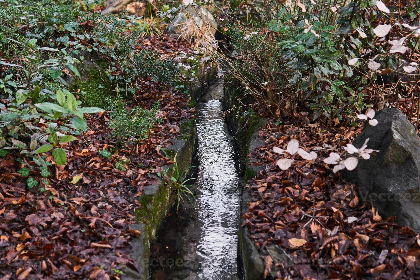 kunstmatig waterloop goot in een steen bed in een park foto