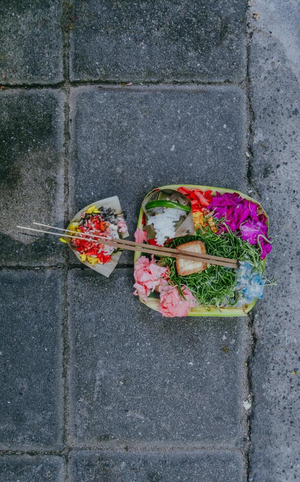 kanang sari, balinees aanbiedingen Aan een steen muur. klein religies aanbieden gemaakt uit van bloemen. traditioneel dagelijks in Bali aanbod. foto