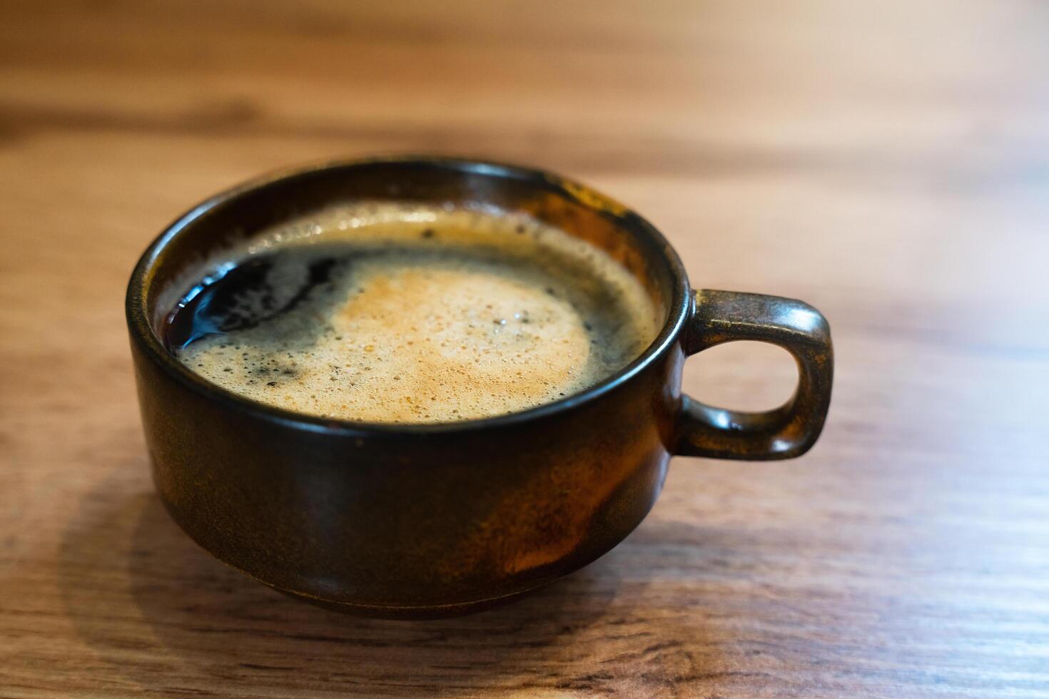 een kop van geurig vers koffie Aan houten tafel Bij cafe. detailopname. selectief focus. foto