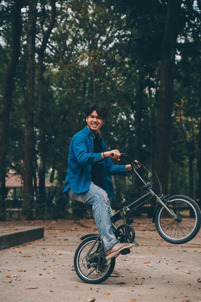 jong knap gebaard Mens nemen een breken terwijl op reis de stad met zijn fiets gebruik makend van zijn digitaal tablet op zoek weg bedachtzaam foto