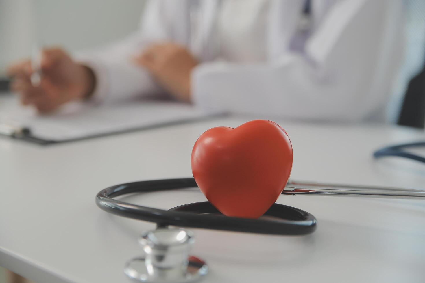 handen van dokter vrouw Holding rood hart, tonen symbool van liefde, menselijk ondersteuning naar geduldig, bevorderen medisch verzekering, vroeg controle voor gezondheidszorg, cardioloog helpen. dichtbij omhoog van voorwerp foto