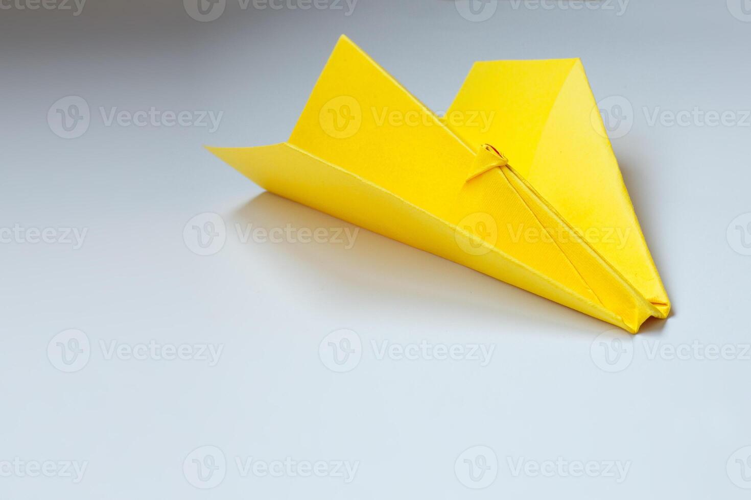 geel origami vlak Aan een wit achtergrond. foto