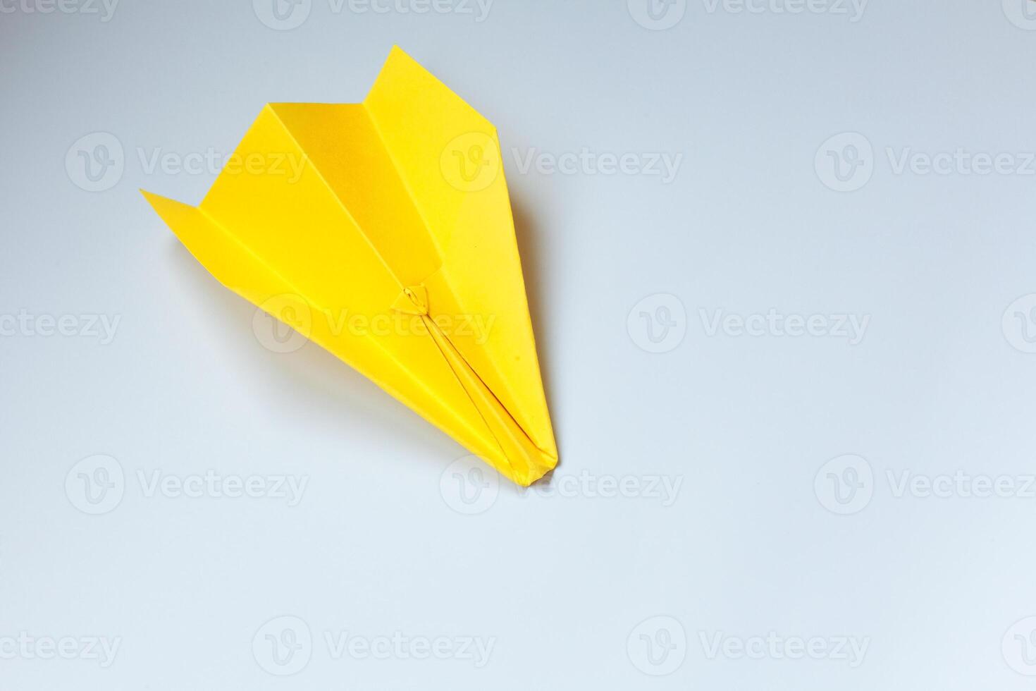 geel origami vlak Aan een wit achtergrond. foto