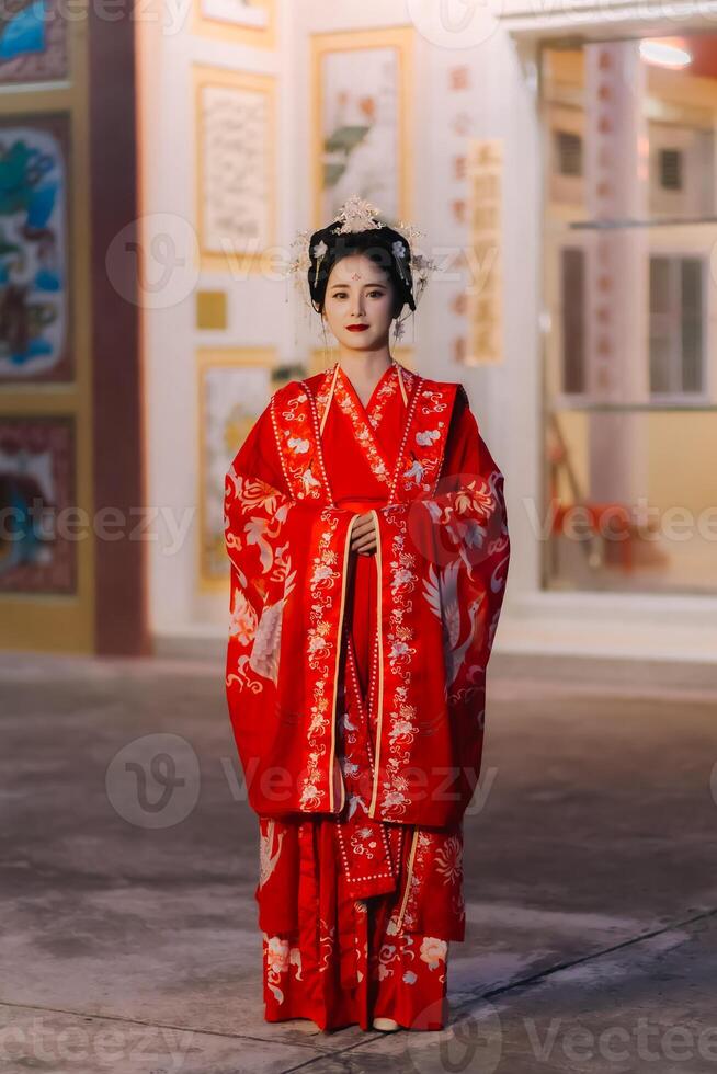 vrouw jurk China nieuw jaar. portret van een vrouw. persoon in traditioneel kostuum. vrouw in traditioneel kostuum. mooi jong vrouw in een helder rood jurk en een kroon van Chinese koningin poseren. foto