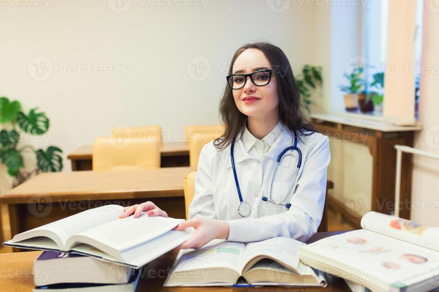 een medisch leerling voor studieboeken. de studie van chirurgie door een mooi meisje in de bibliotheek foto