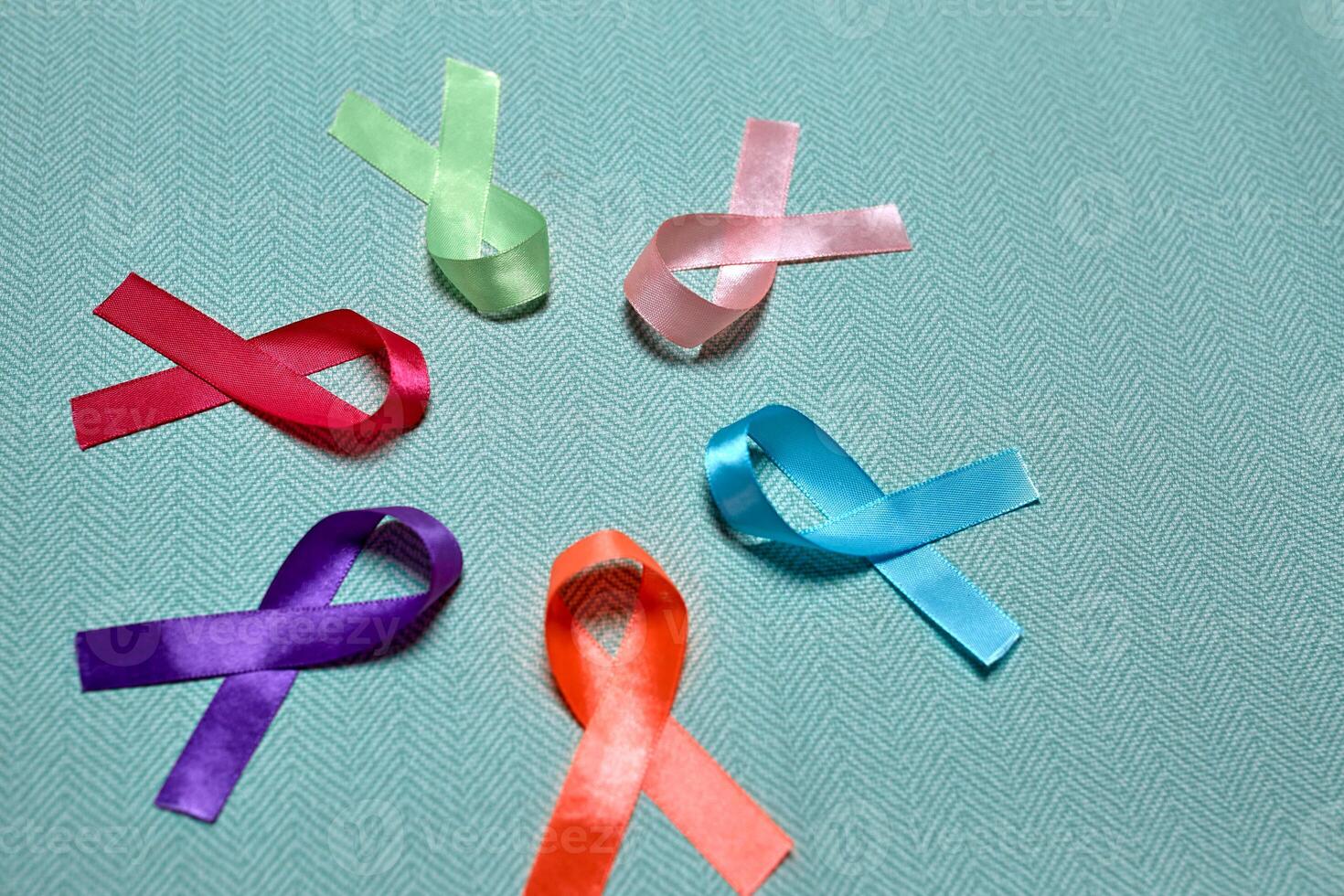 wereld kanker dag. kleurrijk linten, kanker bewustzijn, blauw achtergrond. Internationale agentschap voor Onderzoek Aan kanker foto