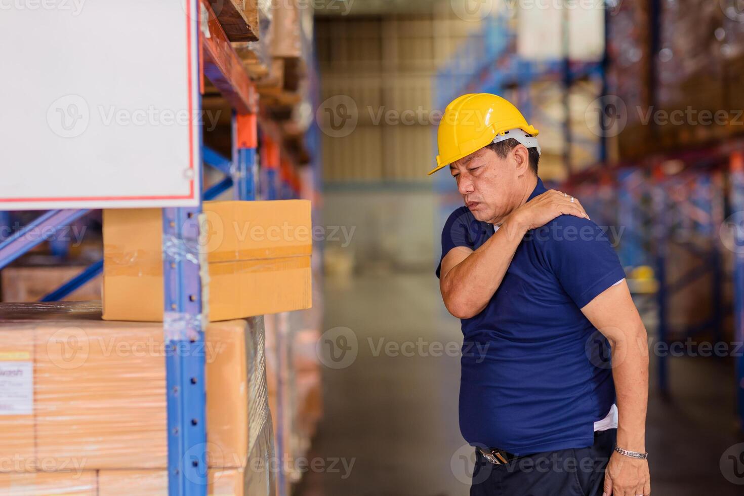 magazijn arbeider terug schouder spier pijn verwondingen van zwaar hijs- moeilijk werken. foto