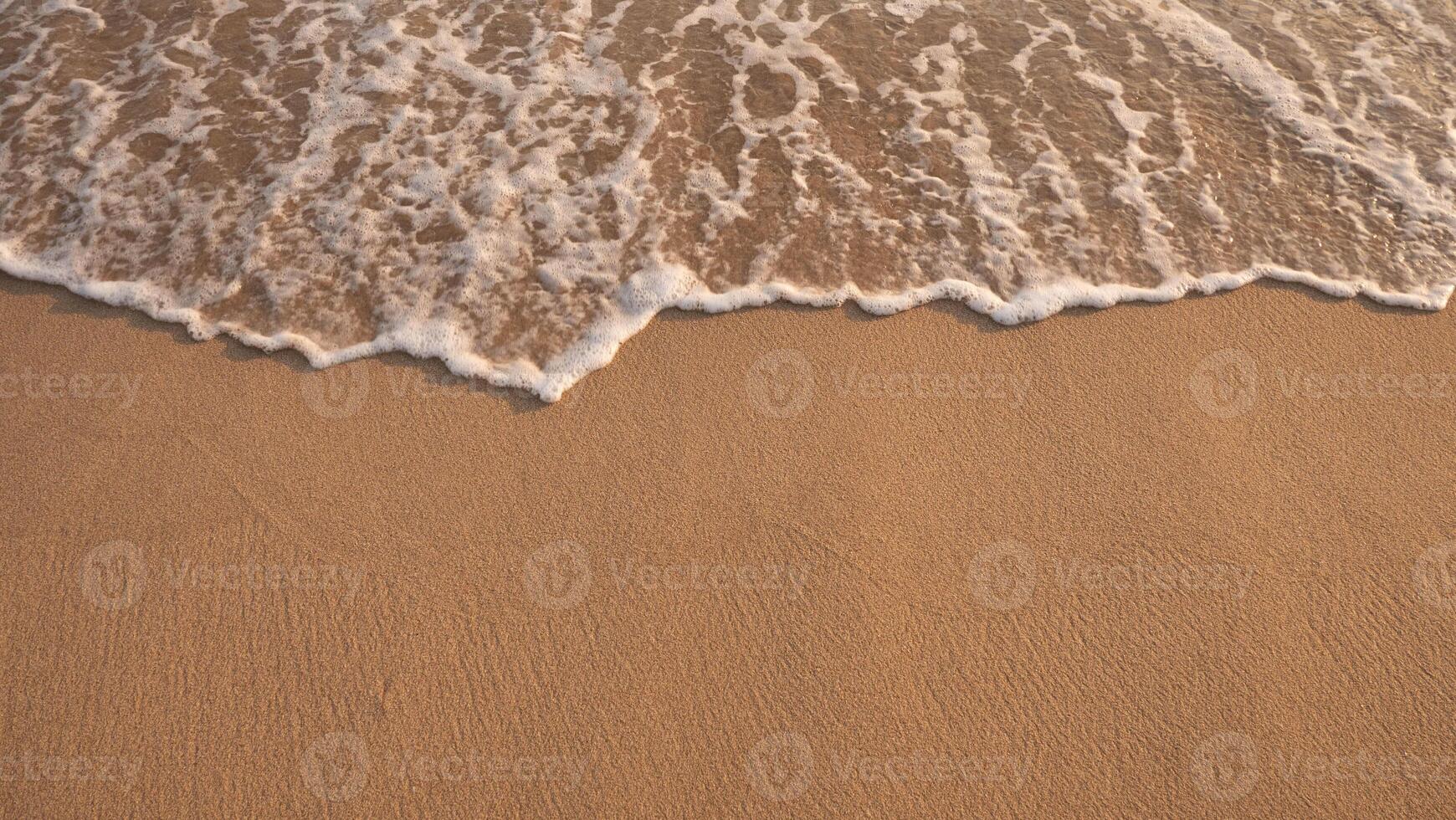 wit schuimend achtergrond van golven crashen Aan een zanderig strand. foto