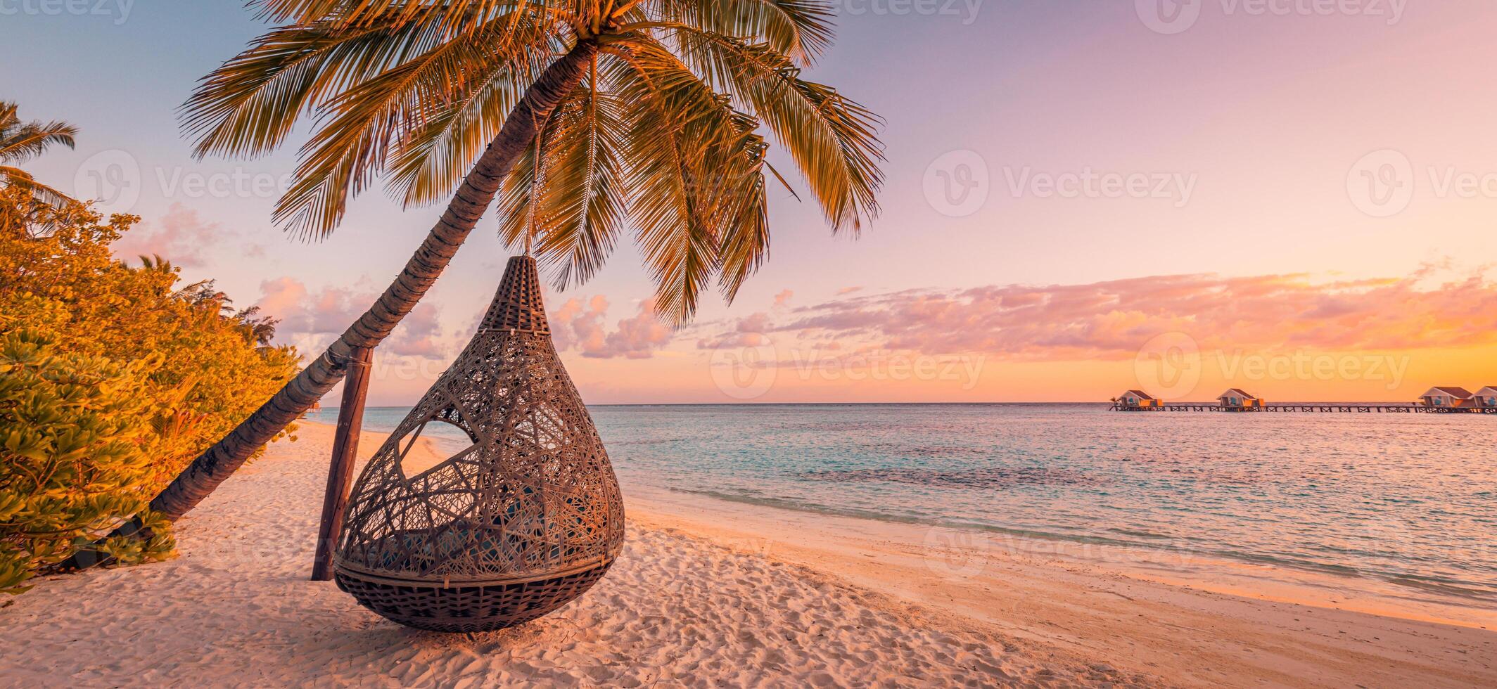 tropisch zonsondergang strand achtergrond, zomer eiland landschap met strand schommel of hangmat en zand romantisch zee strand. mooi strand tafereel vakantie of zomer vakantie concept. huwelijksreis, romance toevlucht foto