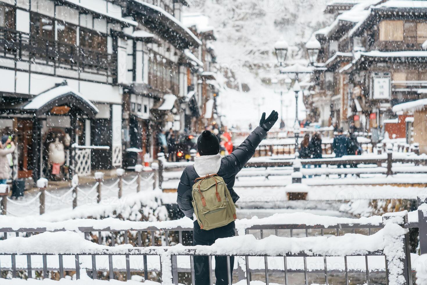 vrouw toerist bezoekende ginzan onsen in yamagata, gelukkig reiziger bezienswaardigheden bekijken Japans onsen dorp met sneeuw in winter seizoen. mijlpaal en populair voor attractie in Japan. reizen en vakantie concept foto