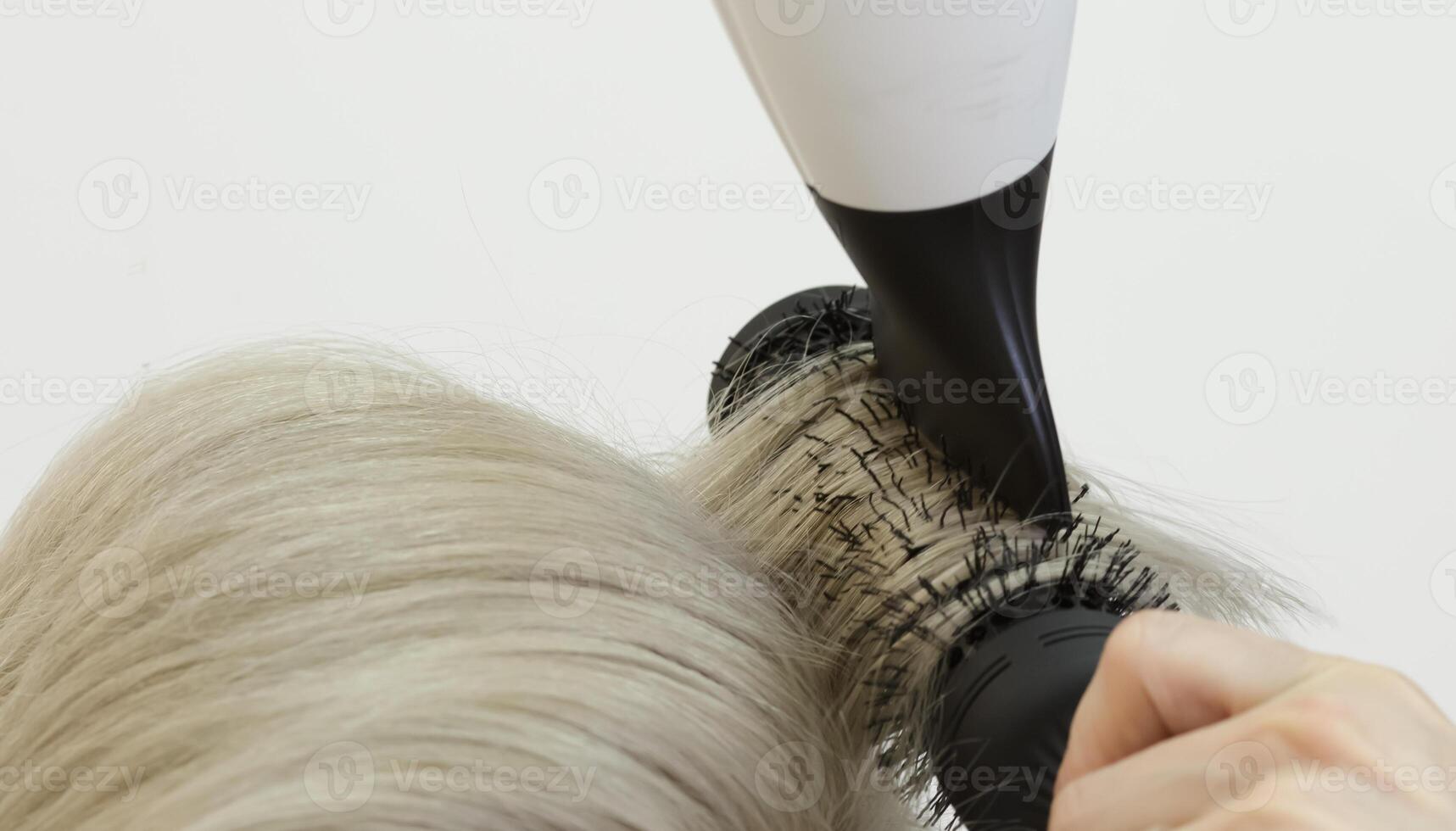 onzichtbaar kapper handen lijn de blond model- haar- gebruik makend van een haar- droger en kam. selectief focus .hoog kwaliteit foto