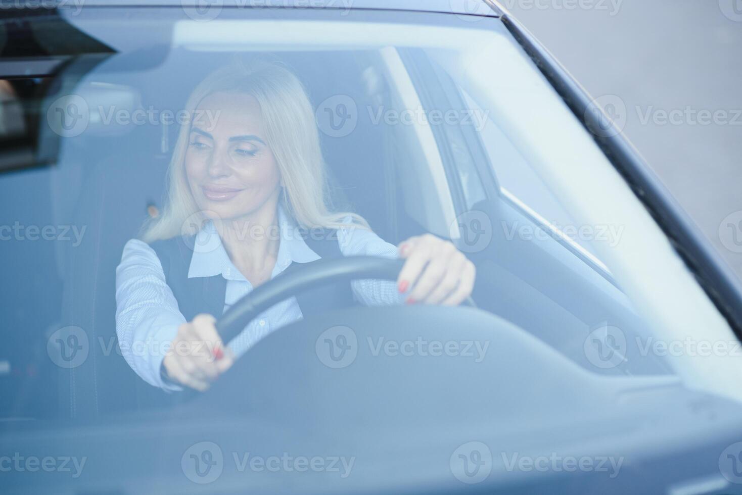 portret van bedrijf elegant middelbare leeftijd vrouw in auto. foto