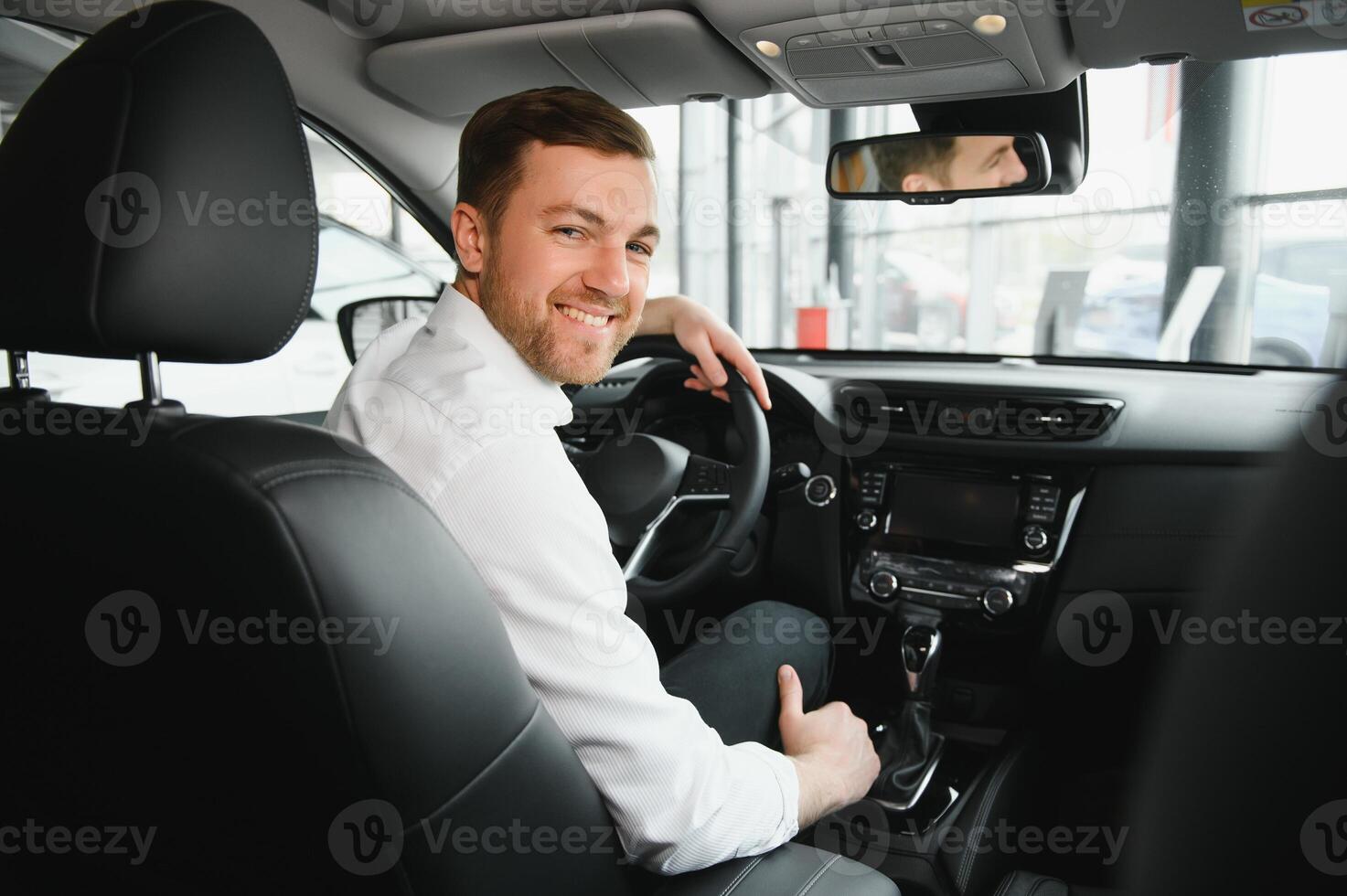 taxi bestuurder glimlachen terwijl draaien over- naar de achterbank op zoek pratend met klanten. geslaagd zakenman man op zoek Bij de achterbank Bij handelaar winkel voordat buying een auto foto